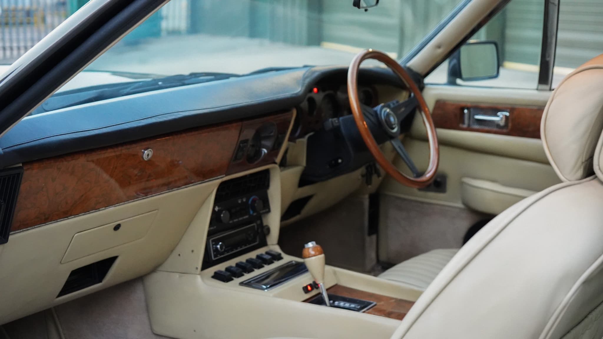 1985 Aston Martin V8 Saloon Series 4 “Oscar India” interior showing the cream leather dashboard and front cabin.