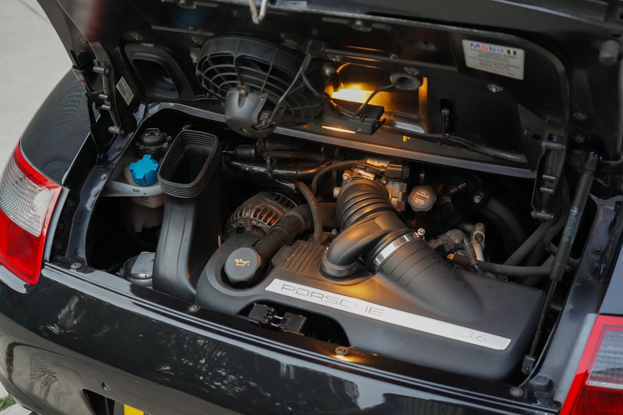 Black 2006 Porsche 911 (997) Carrera Cabriolet showing the engine bay wide.