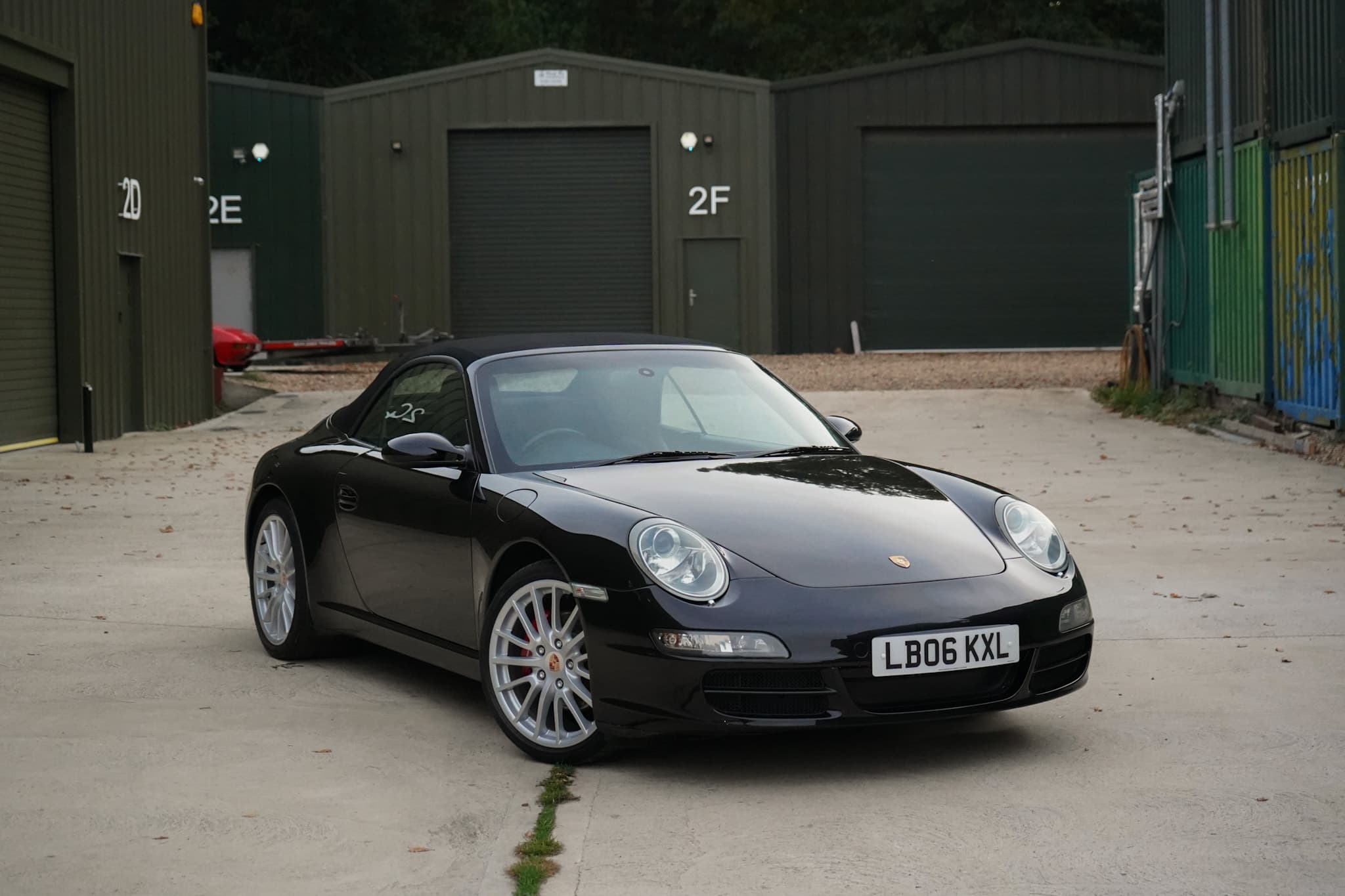 Black 2006 Porsche 911 (997) Carrera Cabriolet in a front three-quarter view.