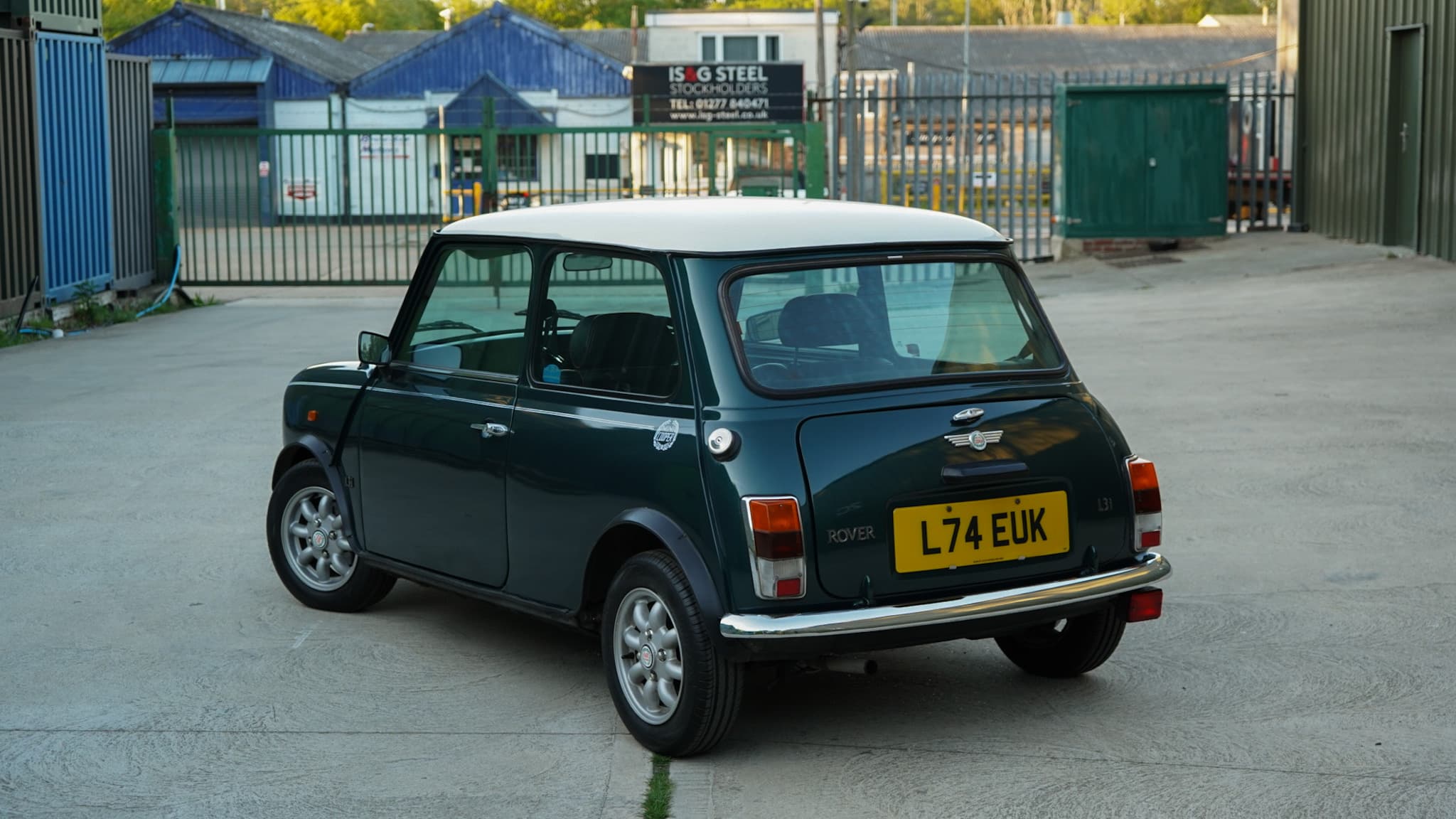 Dark green with white roof 1993 Rover Mini Automatic in a wide rear three-quarter view.