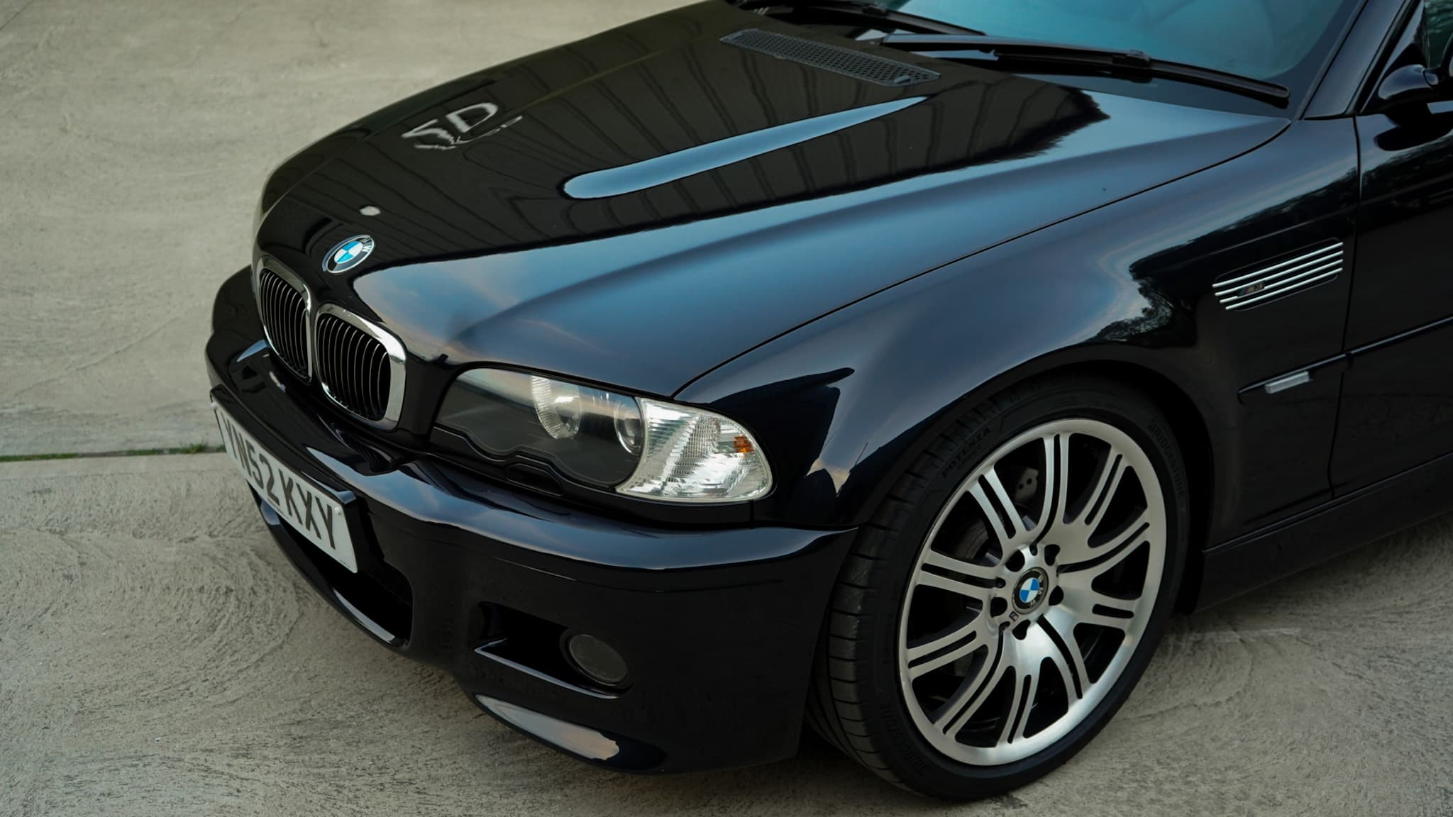 Black 2002 BMW M3 (E46) Manual in a front three-quarter view from a high angle.