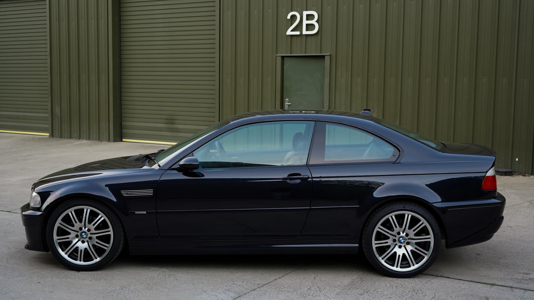 Black 2002 BMW M3 (E46) Manual in a side profile from the opposite side.