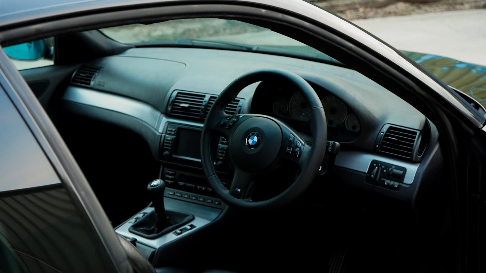 2002 BMW M3 (E46) Manual interior showing the steering wheel dashboard and manual shifter.