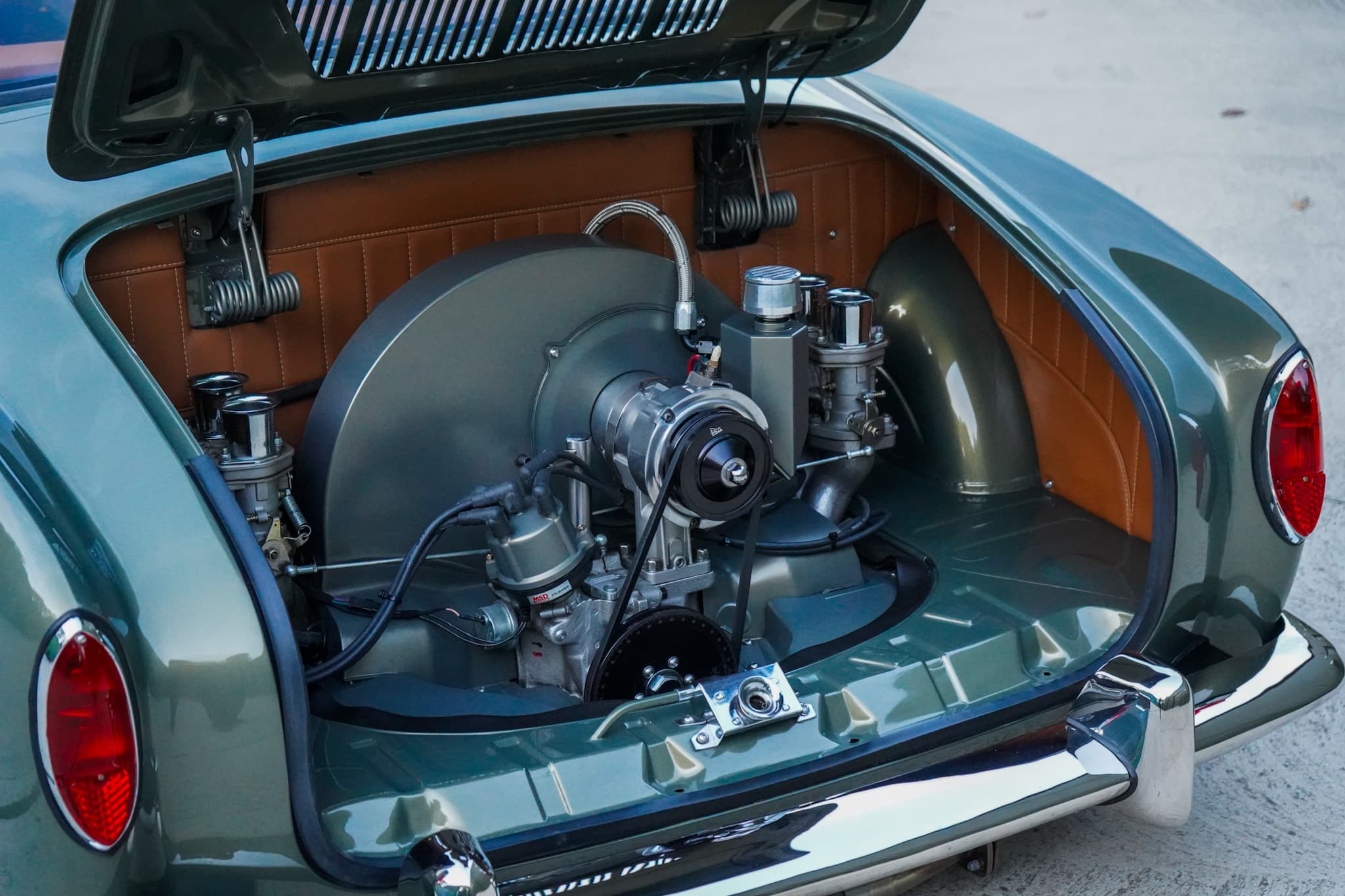 Green Volkswagen Karmann Ghia Type 14 Restomod showing the open engine bay from a rear three-quarter angle.