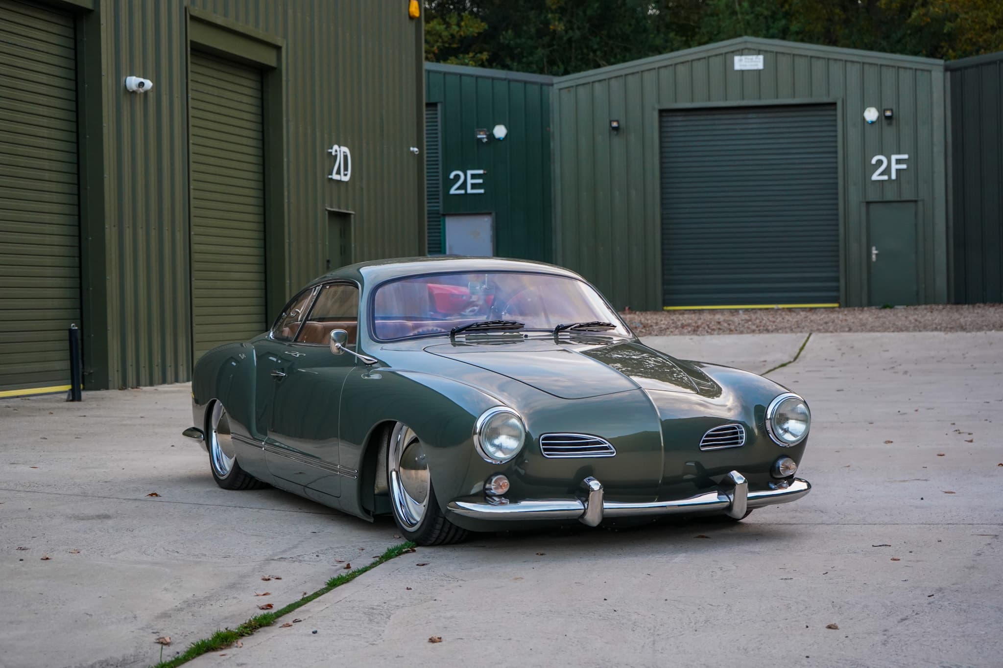 Green Volkswagen Karmann Ghia Type 14 Restomod in a wide front three-quarter view.
