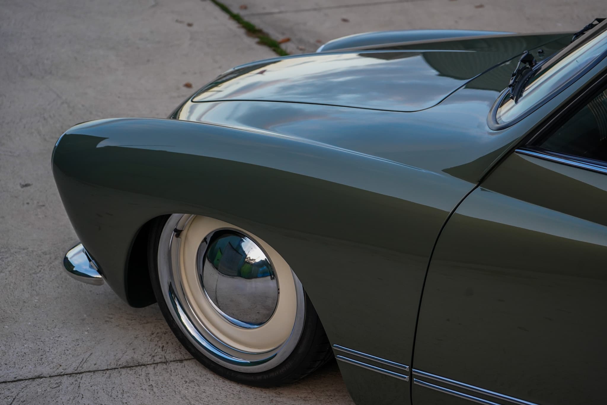 Green Volkswagen Karmann Ghia Type 14 Restomod showing the front wheel and wing close-up.