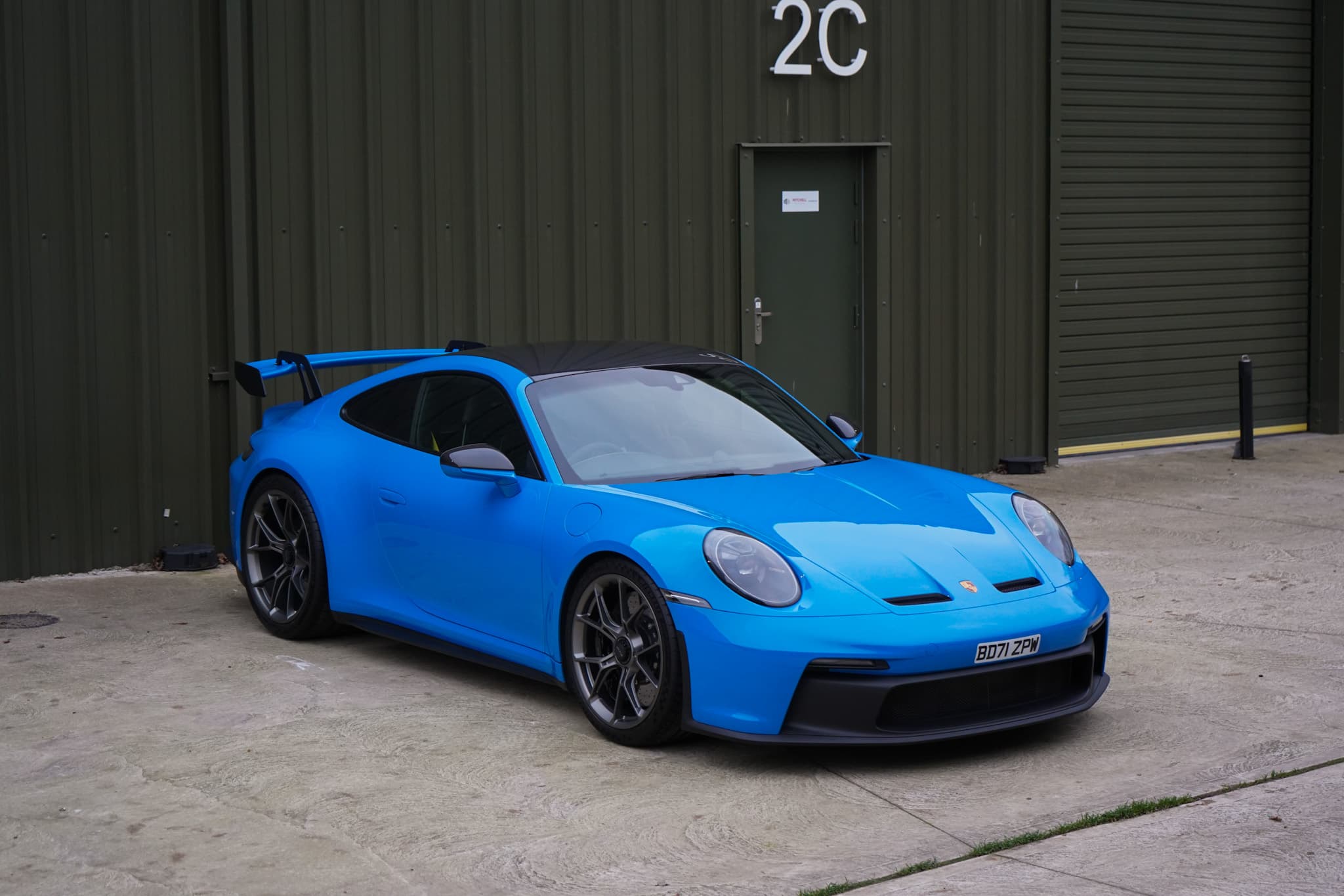 Shark Blue 2022 Porsche 911 (992) GT3 in a front three-quarter view.