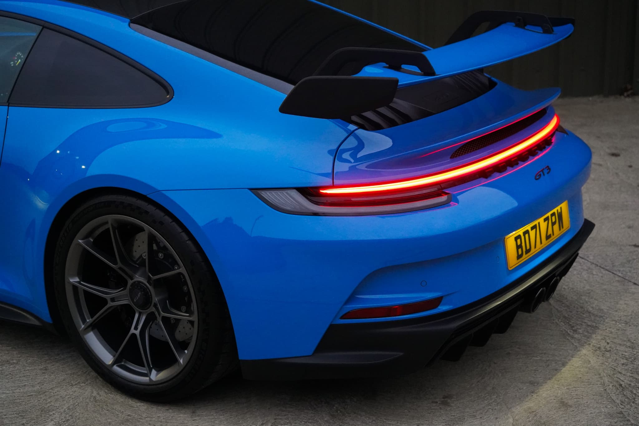 Shark Blue 2022 Porsche 911 (992) GT3 in a close rear three-quarter view.