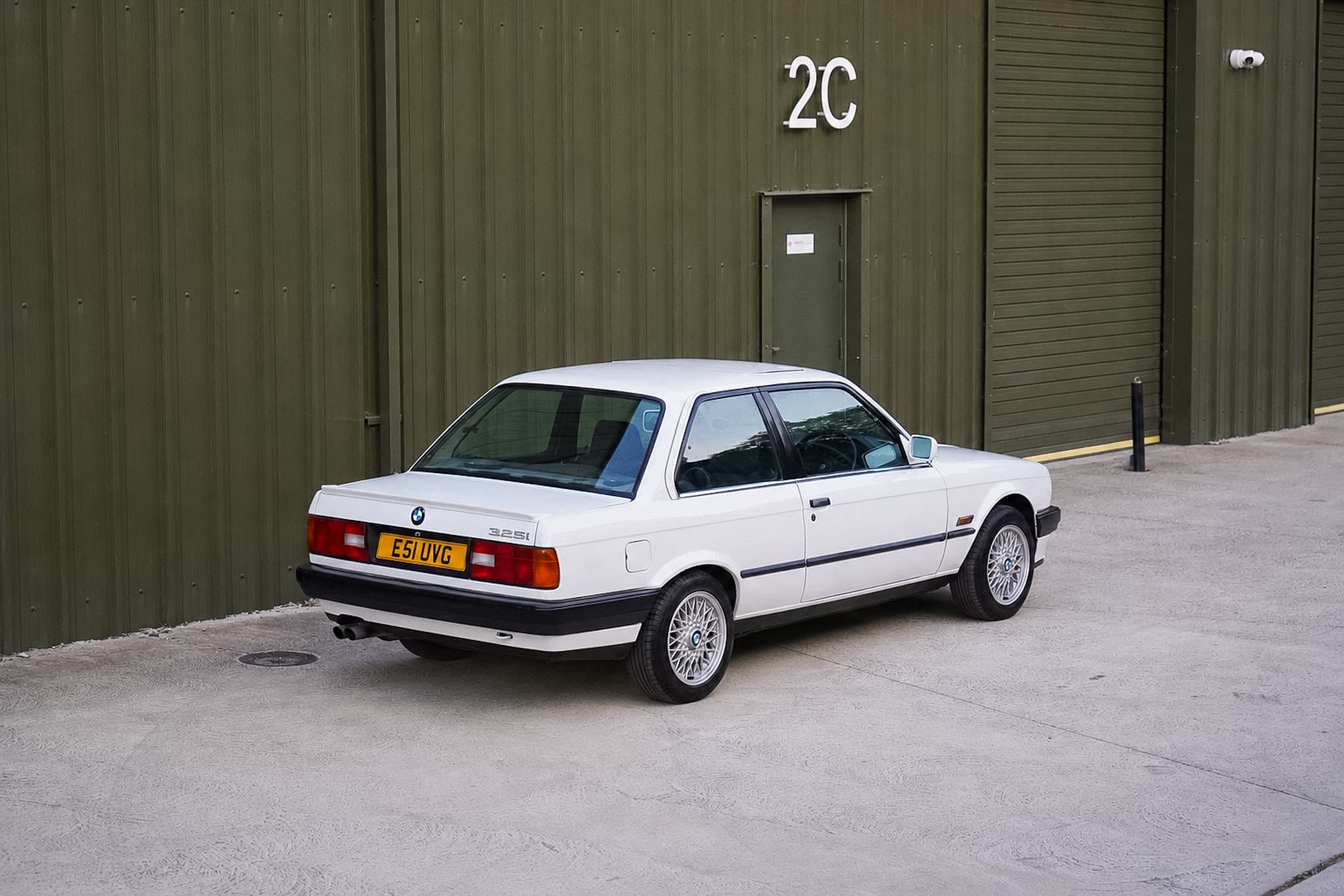 White BMW 325i (E30) Manual Coupe rear three-quarter view.