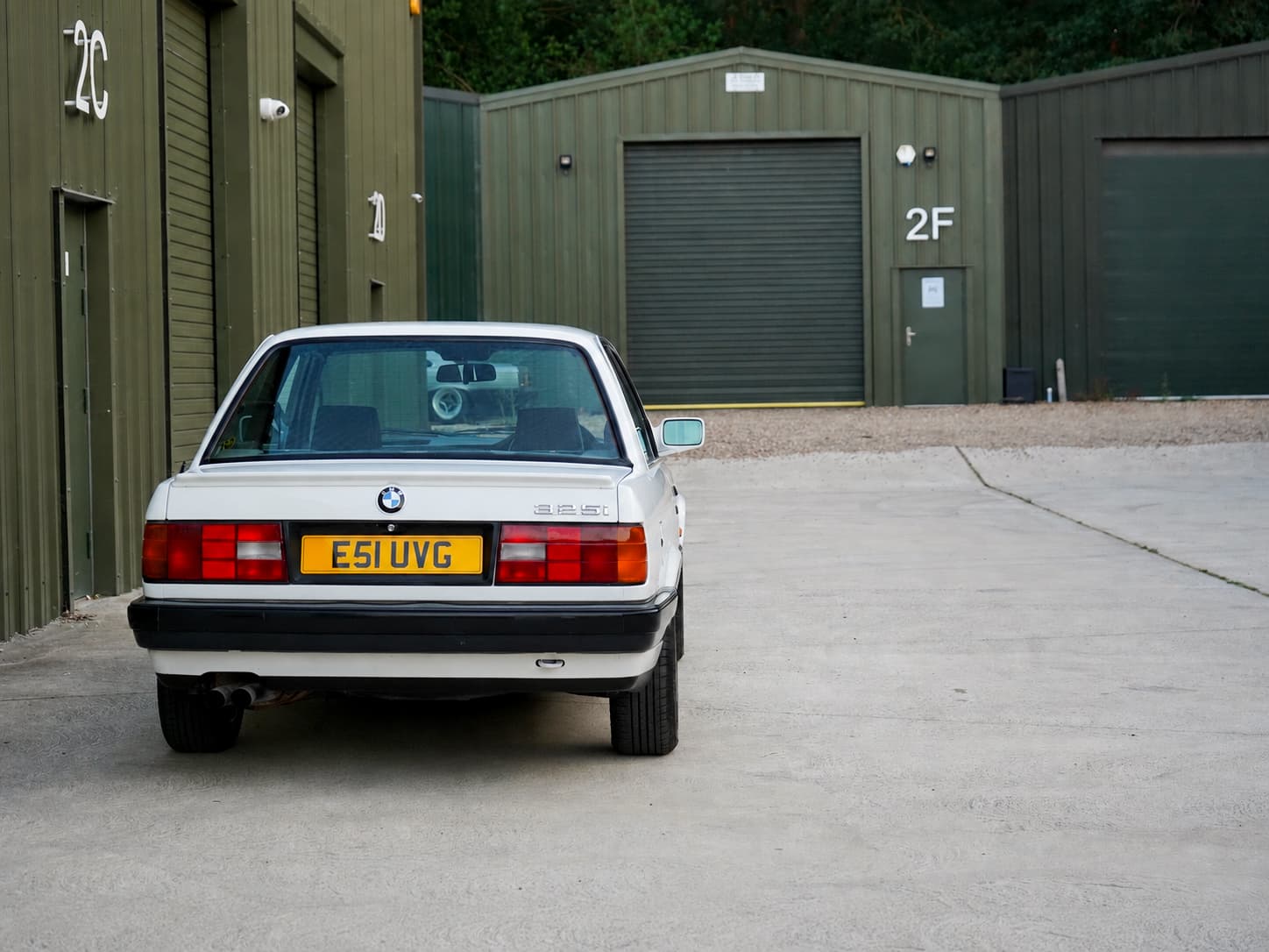 White BMW 325i (E30) Manual Coupe straight rear view.